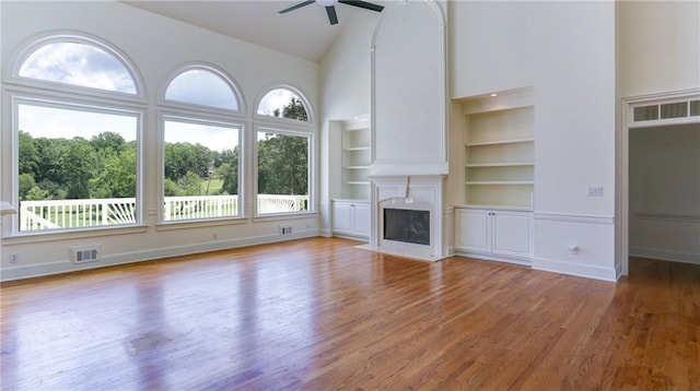 127 Grandmar Chase, Canton, GA 30115 - unfurnished living room with high vaulted ceiling, ceiling fan, wood finished floors, built in shelves, and a fireplace with flush hearth