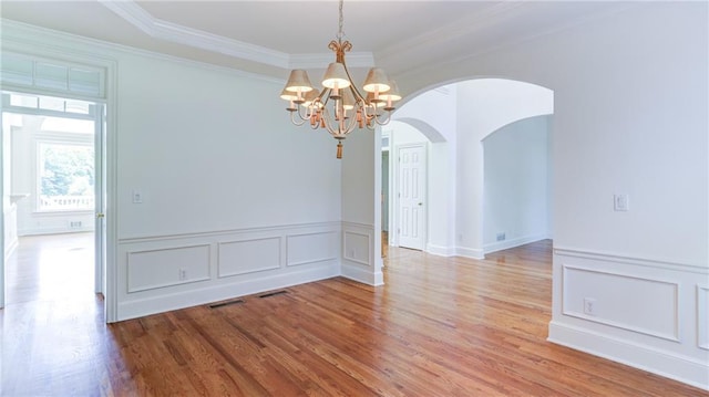 127 Grandmar Chase, Canton, GA 30115 - empty room featuring arched walkways, crown molding, a chandelier, light wood finished floors, and a decorative wall