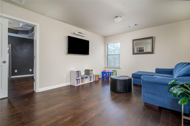 living room featuring wood finished floors, visible vents, and baseboards