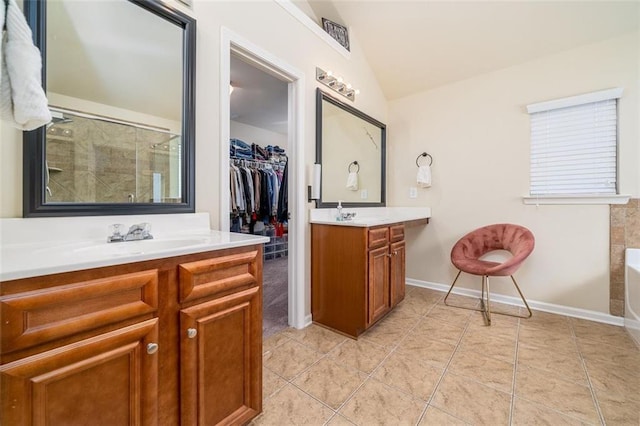 bathroom with tile patterned floors, lofted ceiling, two vanities, and a shower stall