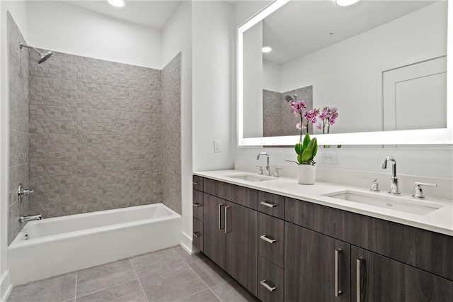 bathroom featuring tile patterned flooring, vanity, and tiled shower / bath