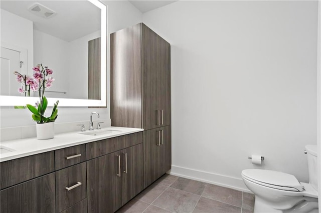 bathroom with toilet, tile patterned flooring, and vanity