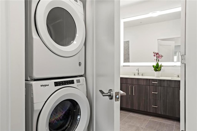 washroom featuring sink, stacked washer and clothes dryer, and light tile patterned floors