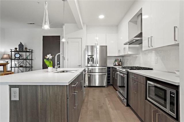 kitchen with stainless steel appliances, decorative light fixtures, white cabinetry, and sink