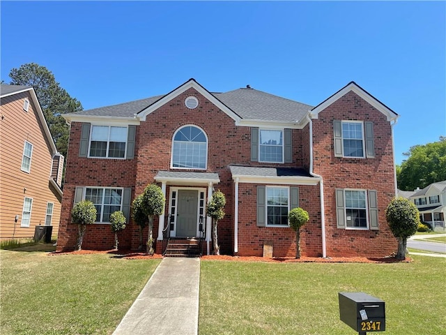 view of front of property with a front yard and brick siding