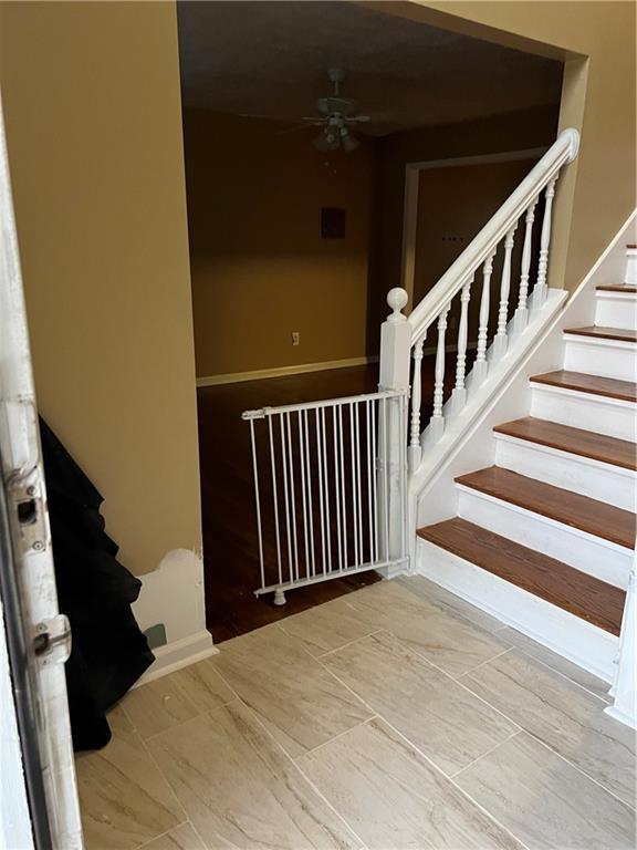 staircase featuring a ceiling fan