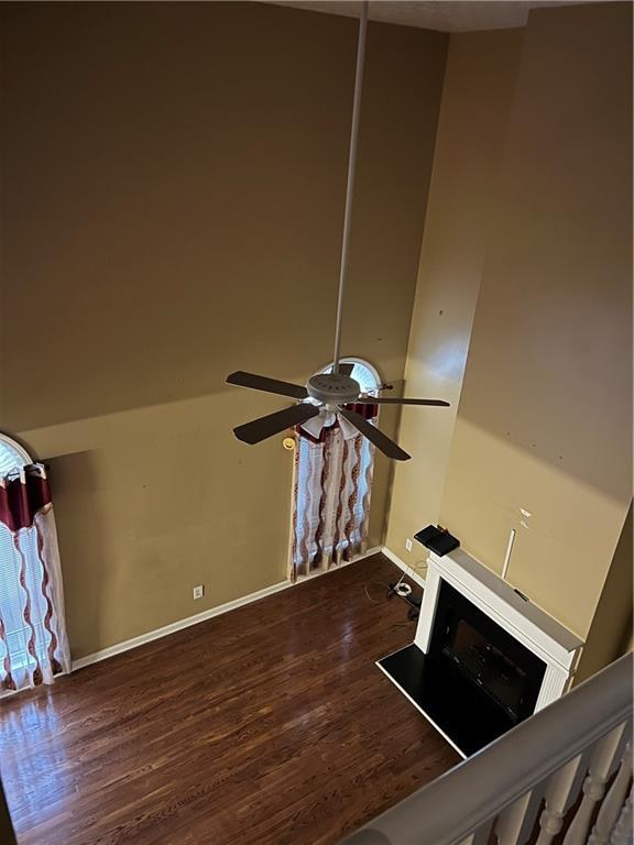 interior space with baseboards, a ceiling fan, and wood finished floors