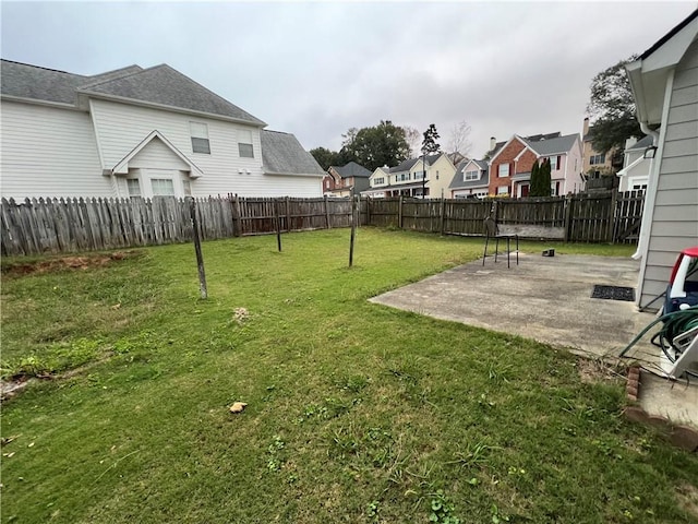 view of yard featuring a patio, a fenced backyard, and a residential view