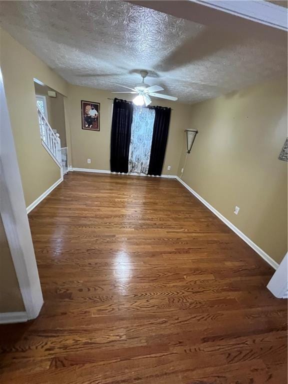 unfurnished room featuring baseboards, a ceiling fan, and wood finished floors