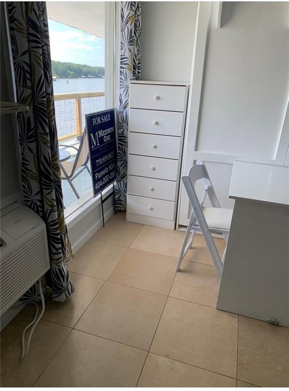 interior space featuring a water view and light tile patterned floors