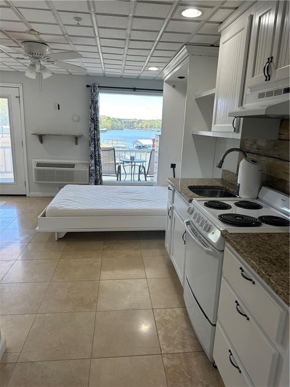 kitchen featuring white electric stove, a healthy amount of sunlight, under cabinet range hood, open shelves, and a sink