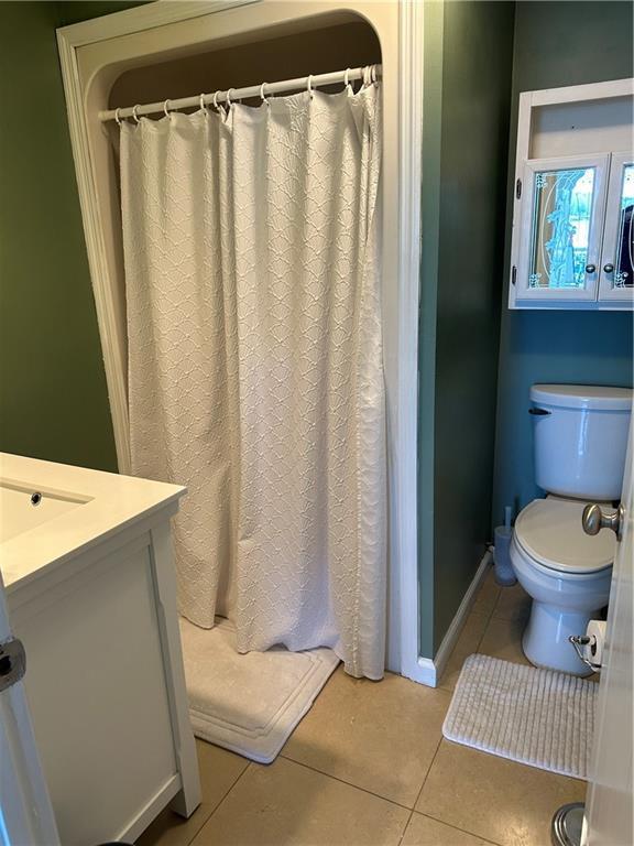 bathroom with vanity, tile patterned flooring, toilet, and baseboards