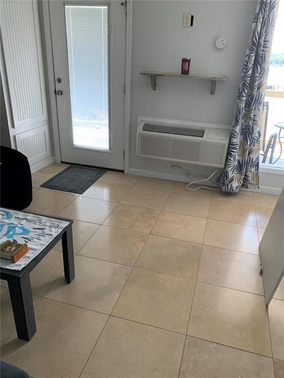 doorway to outside featuring a wall unit AC and tile patterned floors