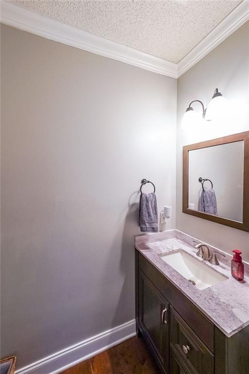 bathroom with vanity, a textured ceiling, hardwood / wood-style flooring, and ornamental molding