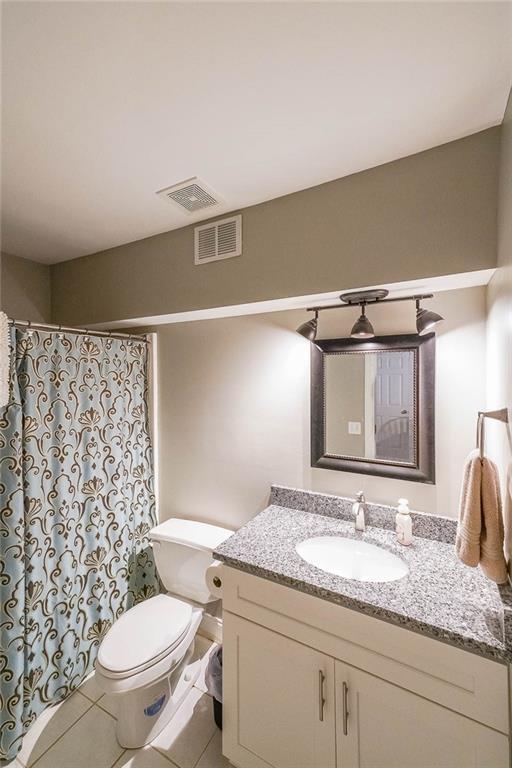 bathroom with tile patterned flooring, vanity, and toilet