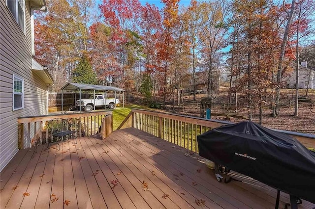 wooden terrace featuring area for grilling and a carport