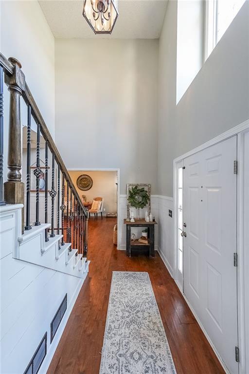 foyer with dark hardwood / wood-style flooring and a towering ceiling