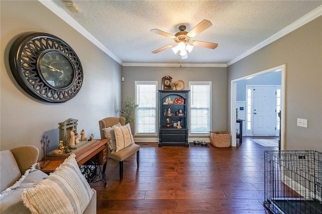 living area with crown molding, ceiling fan, dark wood-type flooring, and a textured ceiling