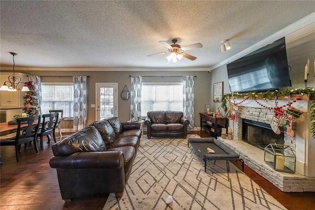 living room featuring hardwood / wood-style flooring, a healthy amount of sunlight, ornamental molding, and a textured ceiling