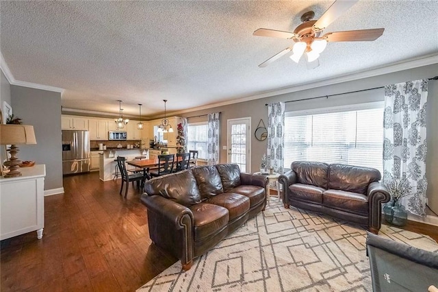 living room with a textured ceiling, light wood-type flooring, ceiling fan, and crown molding