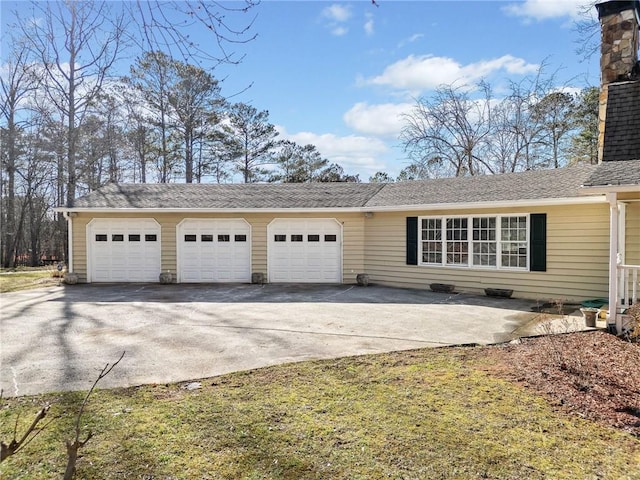 view of front of home featuring a garage, concrete driveway, and a chimney