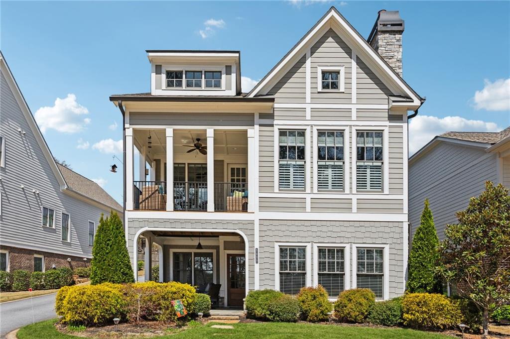 view of front of home featuring ceiling fan, a balcony, and a front yard