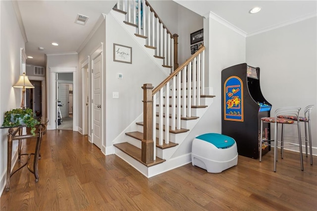 stairs with hardwood / wood-style flooring and ornamental molding