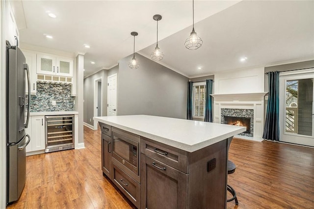 708 Mcgill Pl NE, Atlanta, GA 30312 - kitchen featuring wine cooler, stainless steel appliances, crown molding, white cabinets, and tasteful backsplash