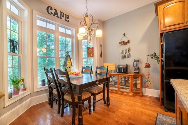 dining room featuring plenty of natural light, light hardwood / wood-style flooring, and a notable chandelier