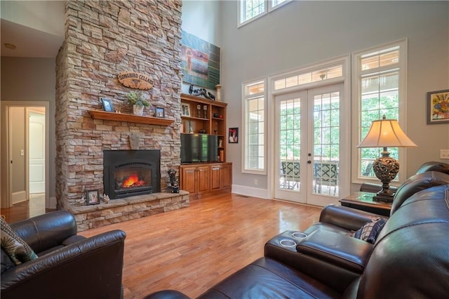 living room with plenty of natural light, a towering ceiling, and french doors