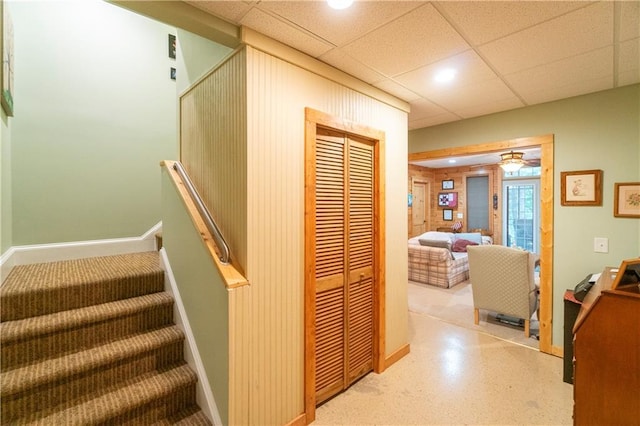 staircase with a paneled ceiling