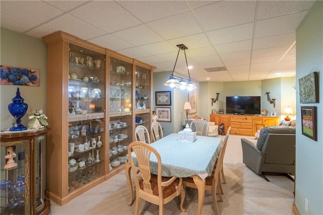 carpeted dining room featuring a drop ceiling