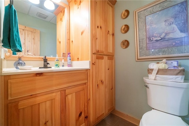 bathroom with tile patterned flooring, vanity, and toilet