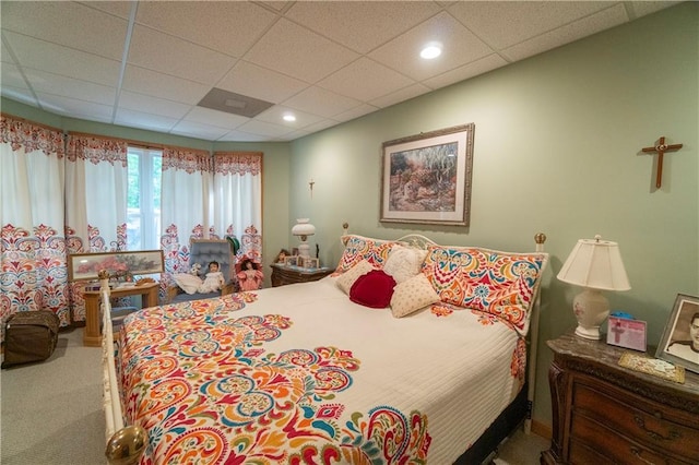 carpeted bedroom featuring a drop ceiling