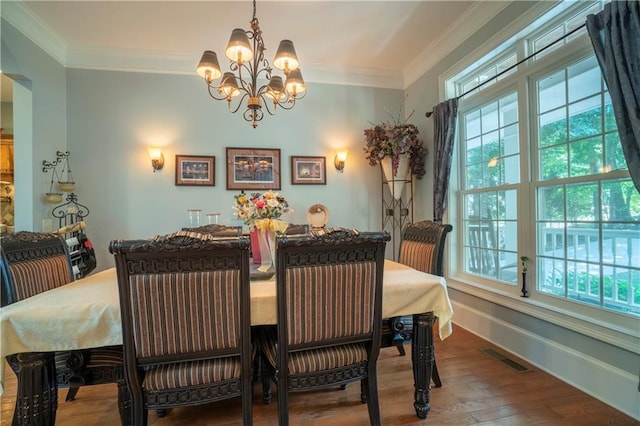 dining space featuring hardwood / wood-style floors, an inviting chandelier, and ornamental molding