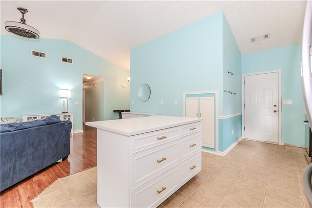 interior space featuring tile patterned floors, lofted ceiling, and vanity