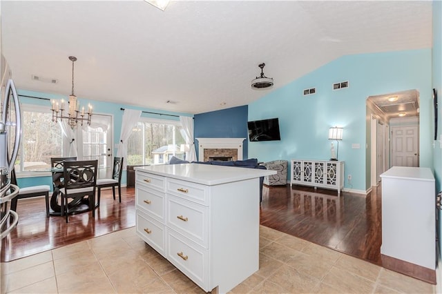 kitchen with hanging light fixtures, white cabinetry, a center island, and light tile patterned floors