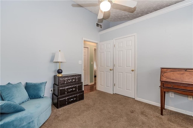 sitting room featuring lofted ceiling, ceiling fan, carpet flooring, ornamental molding, and a textured ceiling