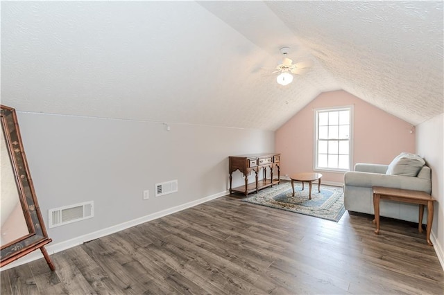 additional living space with ceiling fan, dark hardwood / wood-style flooring, vaulted ceiling, and a textured ceiling