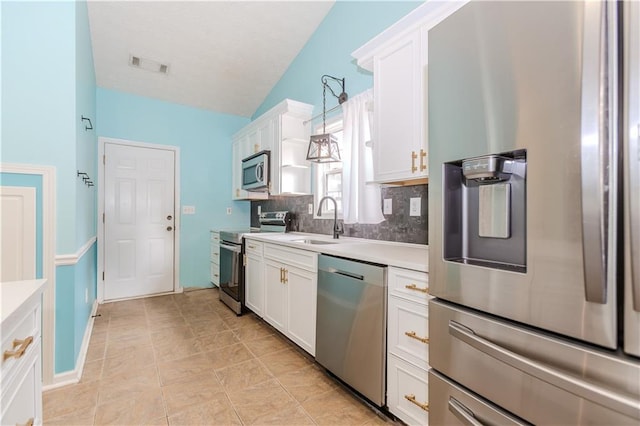 kitchen featuring appliances with stainless steel finishes, sink, hanging light fixtures, and white cabinets