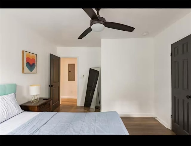 unfurnished bedroom featuring hardwood / wood-style flooring, electric panel, and ceiling fan