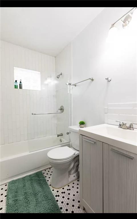 full bathroom with tiled shower / bath, vanity, toilet, and tile patterned floors