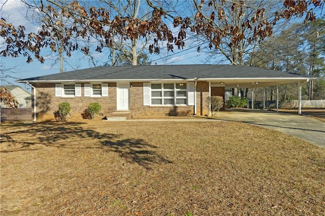 single story home featuring concrete driveway, a front yard, an attached carport, and brick siding