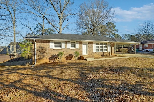 single story home with a carport, brick siding, and a front yard