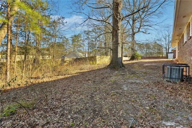 view of yard with fence and central AC unit