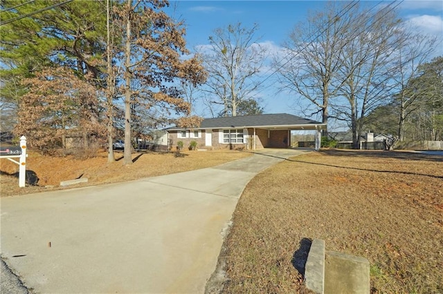 ranch-style home with concrete driveway and an attached carport