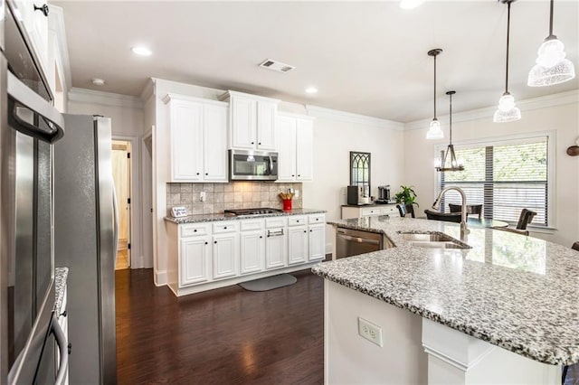 kitchen featuring hanging light fixtures, sink, a center island with sink, white cabinetry, and appliances with stainless steel finishes