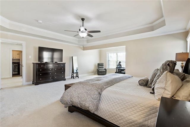 bedroom featuring ceiling fan, a tray ceiling, ornamental molding, and carpet