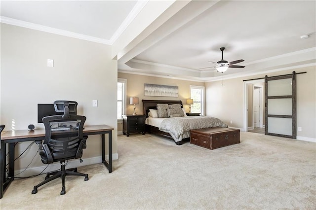 carpeted bedroom featuring a barn door, a tray ceiling, ornamental molding, and ceiling fan