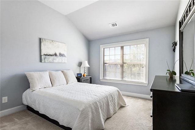 bedroom with lofted ceiling and light colored carpet